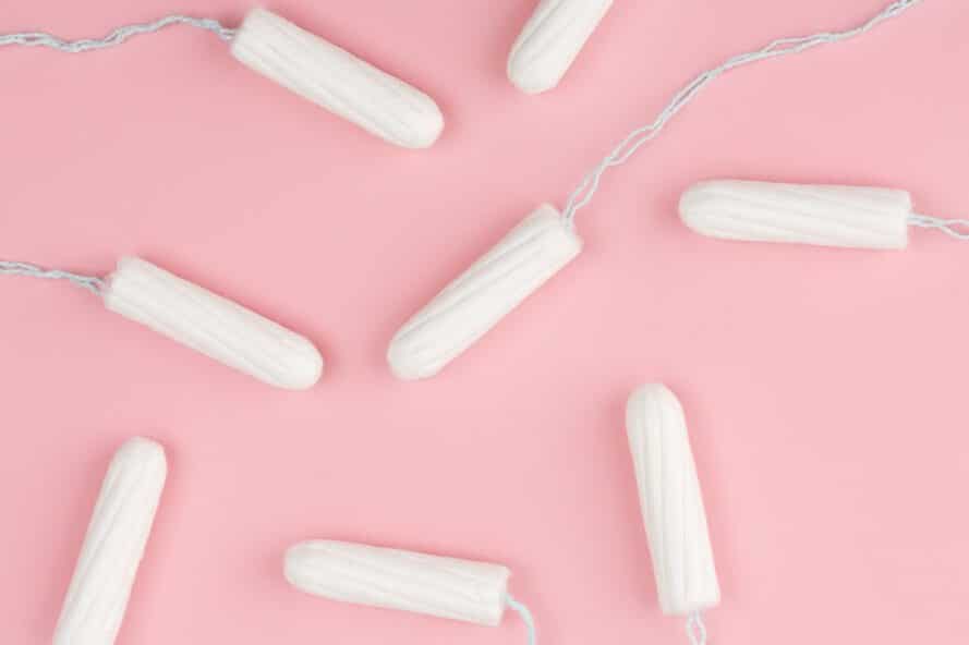 Tampons on table with pink background