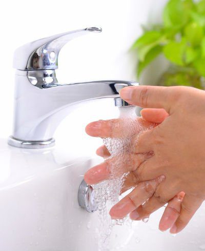 person washing their hands with water