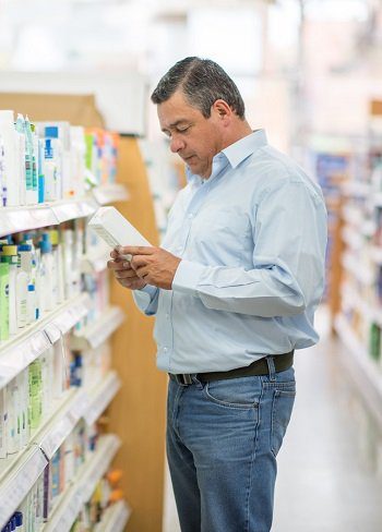 man holding a product in a pharmacy