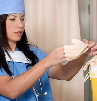 doctor disposing latex gloves into bin