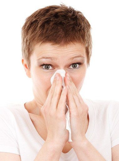 woman blowing her nose with a tissue
