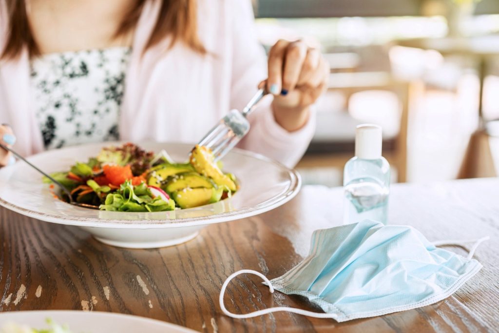 woman using alcohol gel sanitizer before meal
