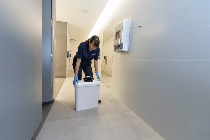 women technician servicing sanitary bin washroom