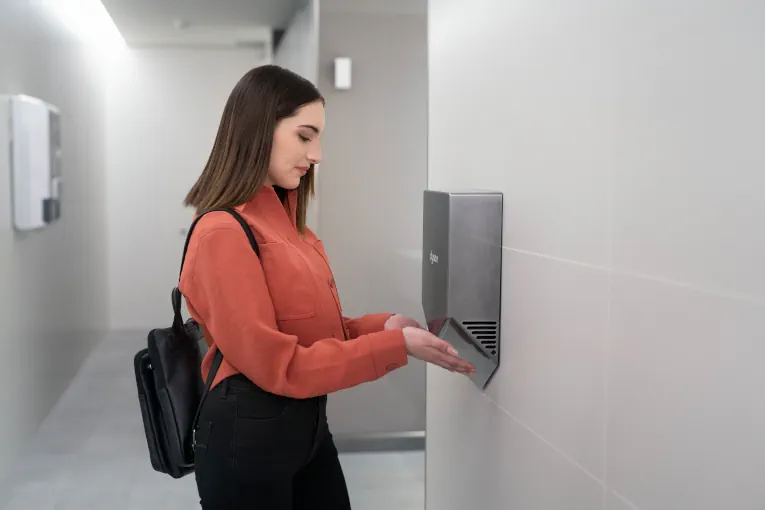 Citron Hygiene woman using Dyson hand dryer in public washroom